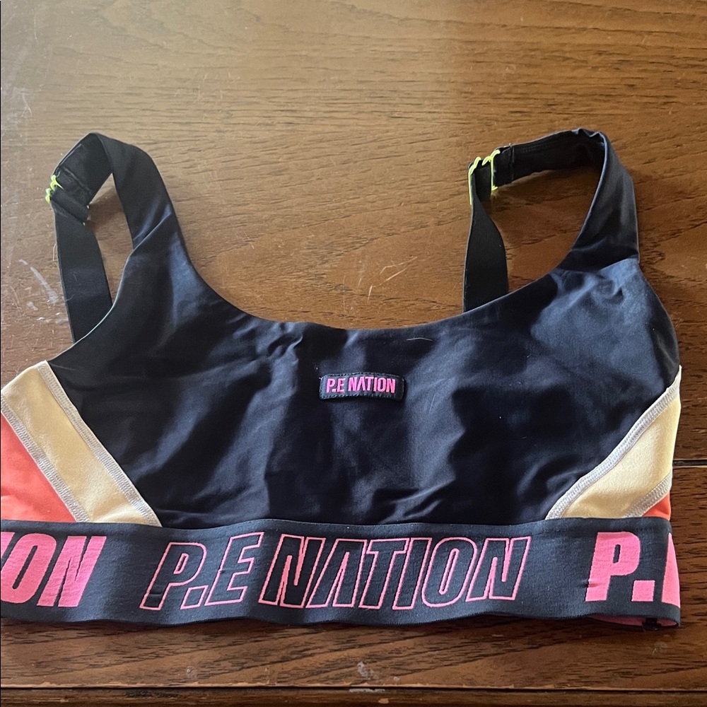 P.E Nation Black Sports Bra with Gold and Pink Accents